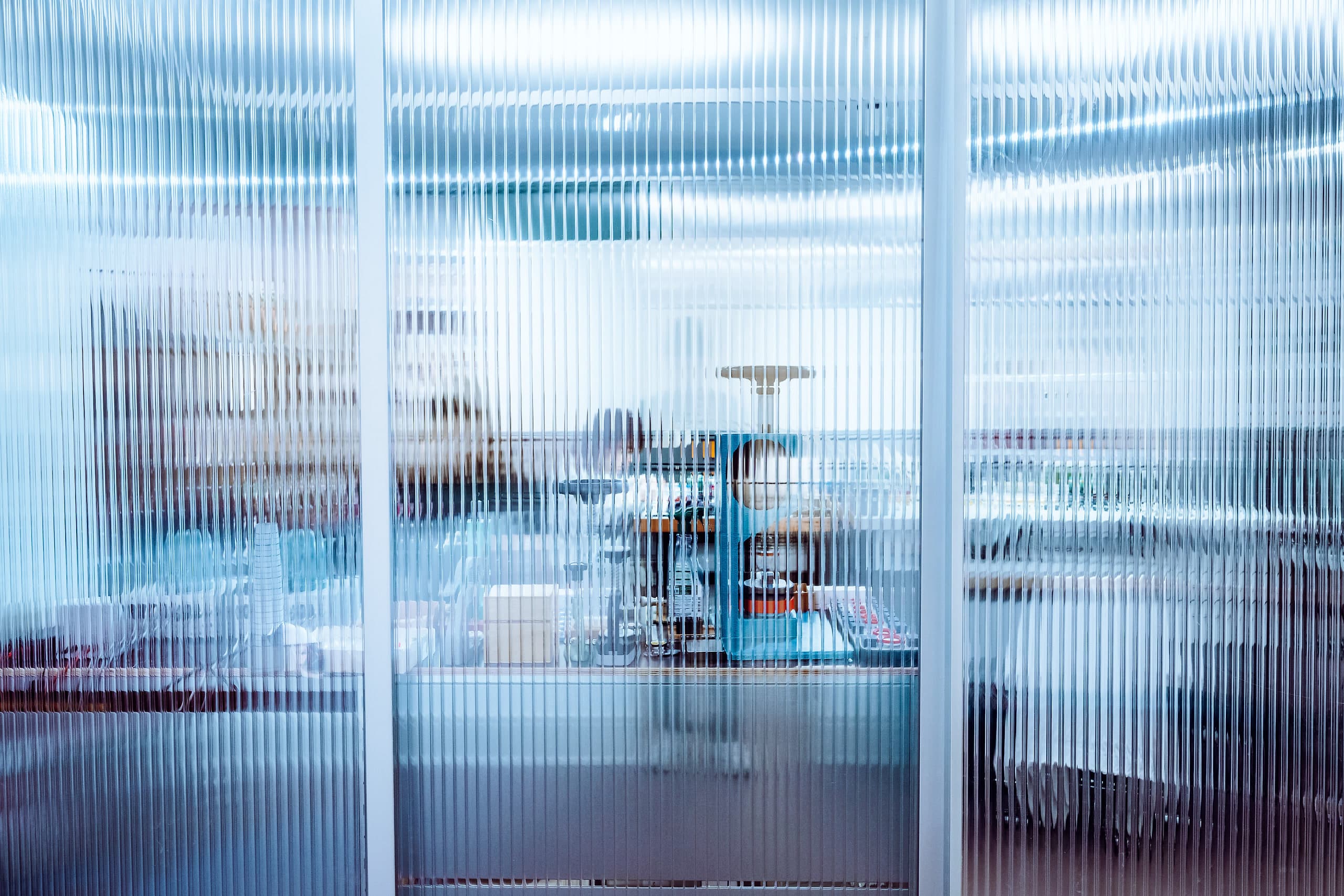 Blick durch die Riffelglaswand in die Uhrmacherwerkstatt