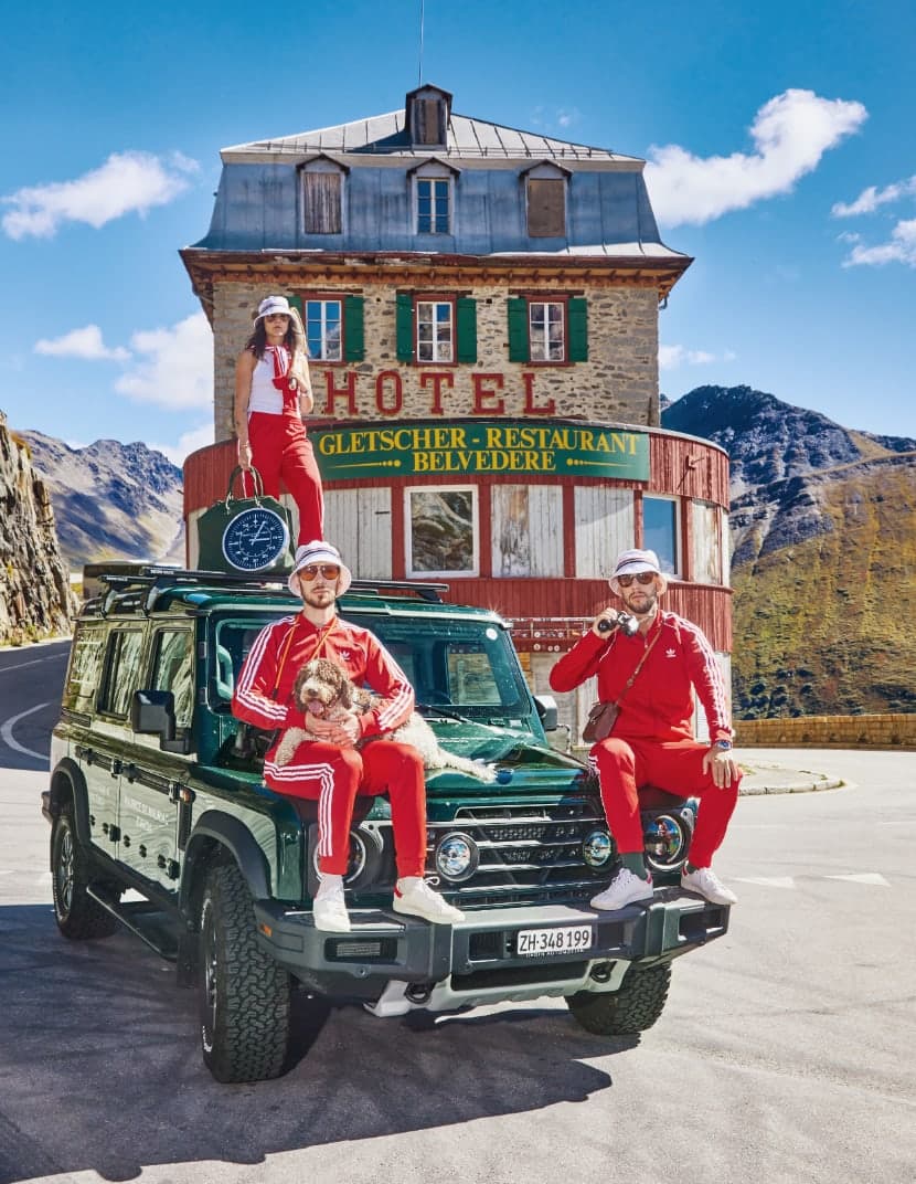 Die Familie Dreifuss in roten Overalls vor dem Hotel Belvedere
